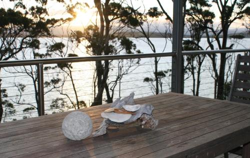 a figurine sitting on a wooden table near the water at Baragoola Retreat - Luxury Waterfront Property in Sandford