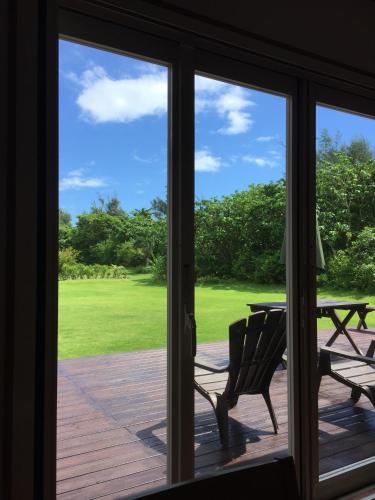 a sliding glass door with a bench and a picnic table at guest house annsea in Ishigaki Island