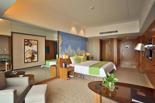 a bedroom with a large bed and a living room at Zhangjiajie Huatian Hotel in Zhangjiajie