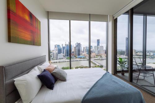 a bedroom with a bed with a view of the city at AirTrip Apartments at South Brisbane in Brisbane