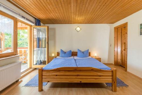 ein Schlafzimmer mit einem großen Holzbett mit blauen Kissen in der Unterkunft Landhaus Breg in Hergensweiler