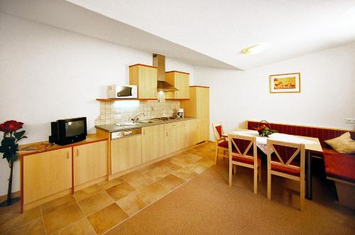 eine Küche mit einem Tisch und einem Esszimmer in der Unterkunft Gästehaus Mrak in Längenfeld