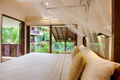 Un pat sau paturi într-o cameră la Jetwing Ayurveda Pavilions - Full Board & Treatments