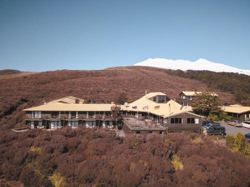 a building on top of a hill with a mountain at Skotel Alpine Resort in Whakapapa Village
