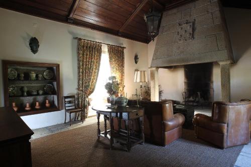 a living room with a table and a fireplace at Paço de Calheiros - Turismo de Habitação in Ponte de Lima