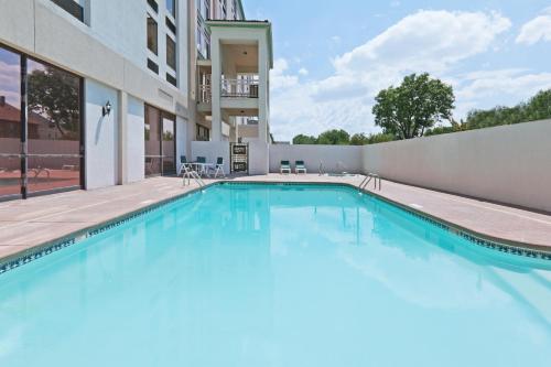 a swimming pool with blue water in a building at Wyndham Garden Wichita Downtown in Wichita