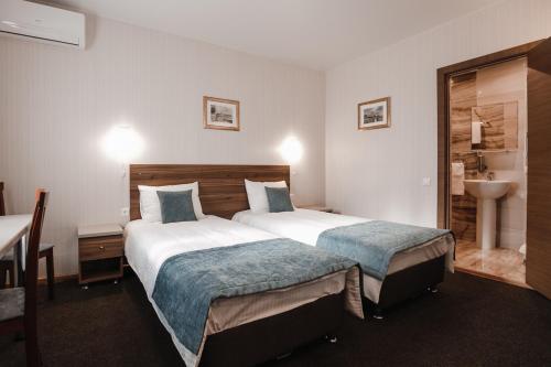 VotkinskにあるLegendaのベッド2台とシンク付きのホテルルームです。