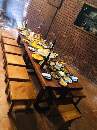 a long wooden table with plates of food on it at Philia's Guest House in Sighnaghi