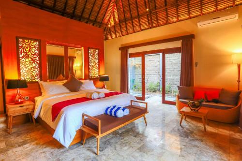 a large bedroom with a large bed and a chair at A Villa Gili Air in Gili Islands