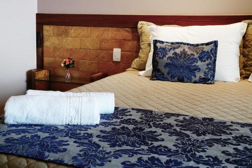 a bed with a blue and white comforter and a pillow at Pousada Meu Talento in Alto Paraíso de Goiás