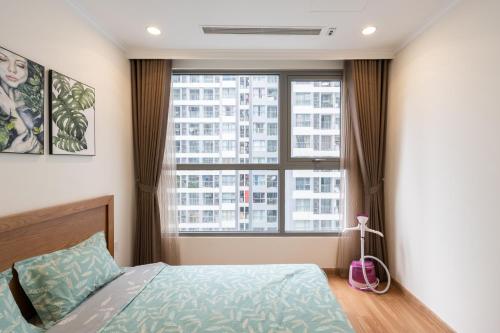 a bedroom with a bed and a large window at Park Hill No1 Apartment in Hanoi