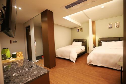 a hotel room with two beds and a mirror at Namyangju Bukhangang dolcecasa hotel in Namyangju