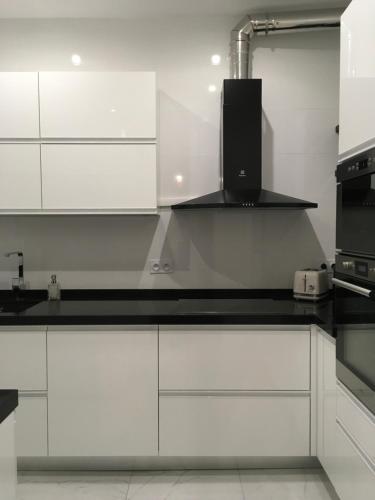 une cuisine avec des armoires blanches et un comptoir noir dans l'établissement Anna’s Home, à Troyes