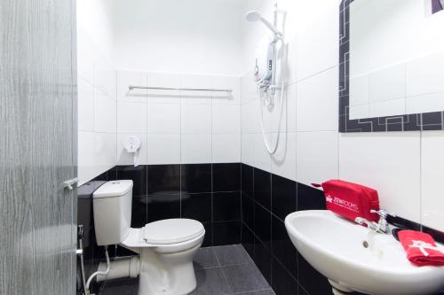 een badkamer met een toilet en een wastafel bij Kampung Guest House in Pantai Cenang