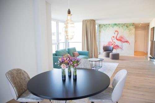 un soggiorno con tavolo e fiori di Gubelhof Suites a Zugo