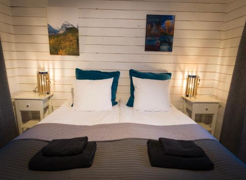 a bedroom with a bed with two pillows on it at Arctic Gourmet Cabin in Kiruna