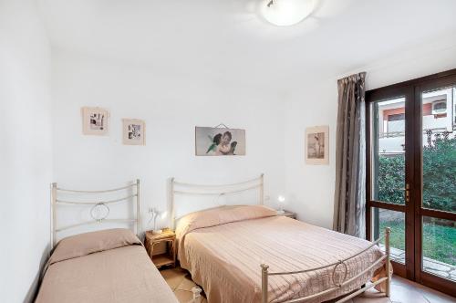 two beds in a white room with a window at Salice in Marina di Campo