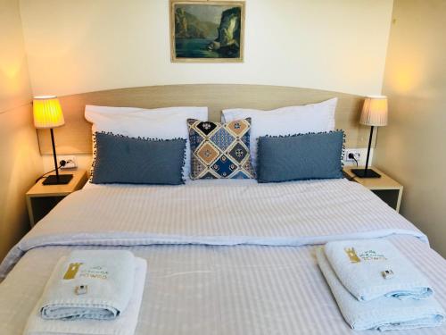 a bedroom with a large bed with towels on it at Villa Vravrona Tower & Suites in Markopoulo