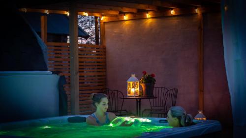 a girl in a hot tub in a room with a table at Ölands Yoga Studio & Islandshästar, Stugor & Rum in Mörbylånga