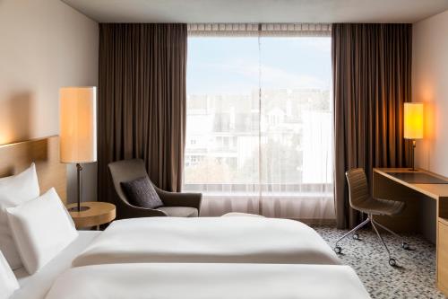 a hotel room with two beds and a window at Pullman Basel Europe in Basel