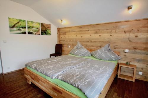 a bedroom with a large bed with a wooden headboard at Basislager Fieberbrunn in Fieberbrunn