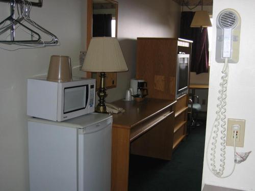 a kitchen with a microwave on top of a refrigerator at Colonial Inn in Brandon