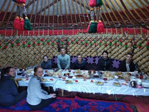 a group of people sitting around a table in a yurt at Yurt Camp Azamat at Song Kol Lake in Bagysh
