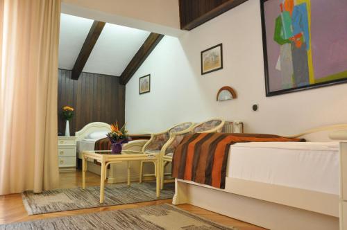a bedroom with three beds and chairs in it at Hotel Simpo Pržar in Vranje