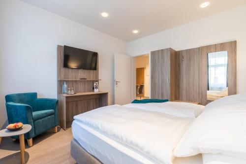 um quarto com 2 camas, uma cadeira e uma televisão em "Sleep & Relax" Apartement em Dresden