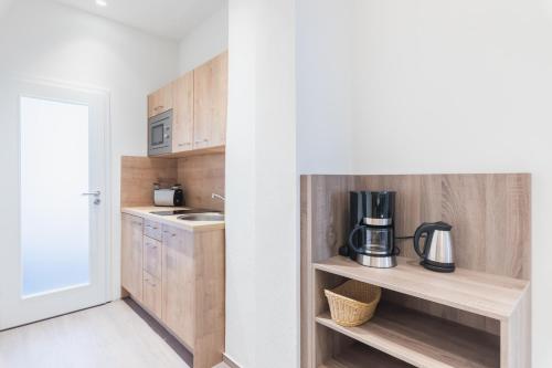 a kitchen with wooden cabinets and a coffee maker on a shelf at "Sleep & Relax" Apartement in Dresden