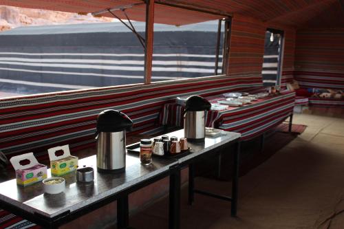 una fila di tavoli in un ristorante con macchine per il caffè di Salem Camp a Wadi Rum