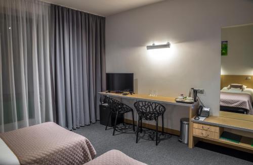 a hotel room with a desk and a bed at Restart in Rēzekne