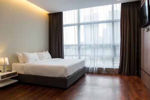 a bedroom with a bed and a large window at Imperial Regency Suites & Petaling Jaya in Kuala Lumpur