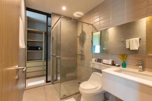 ein Bad mit einer Dusche, einem WC und einem Waschbecken in der Unterkunft Sanae' Hotel Nimman in Chiang Mai