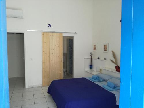 una camera da letto con un letto blu in una stanza bianca di Mediterranea Guesthouse B&B a Portopalo