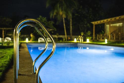 a blue swimming pool with a metal hand rail at Roça Santo António Ecolodge in São Tomé