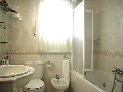 ein weißes Badezimmer mit einem Waschbecken, einem WC und einer Badewanne in der Unterkunft Casa Rural Sancho el Fuerte in Valtierra