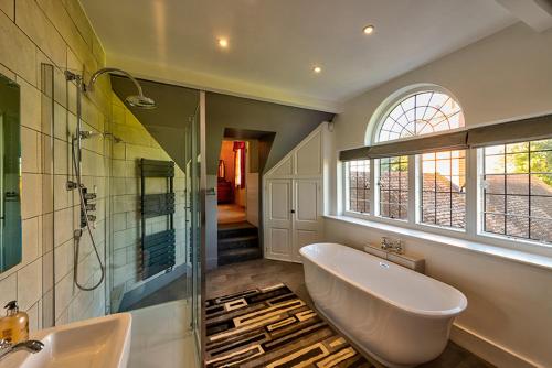 uma casa de banho com uma banheira, um chuveiro e um lavatório. em Saltcote Place em Rye