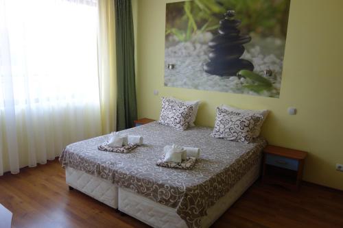 a bedroom with a bed with two towels and a painting at Aquamarine in Sozopol