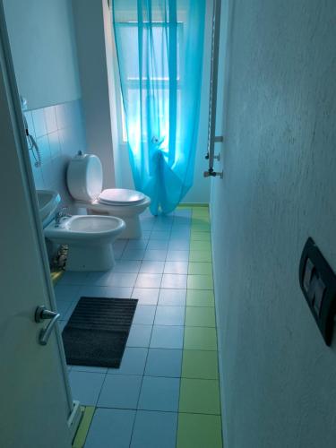 bagno con 2 servizi igienici e tenda doccia blu di Harmony Rooms a Catania