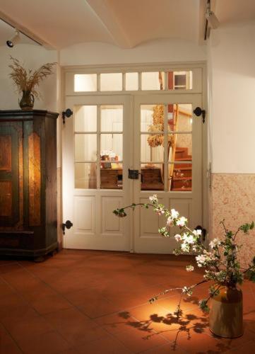 a room with a door and a vase of flowers at Hotel Weisses Ross in Dinkelsbühl
