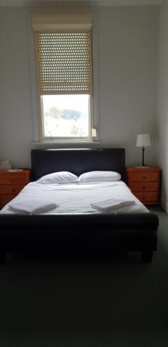 a bedroom with a large bed with a window at The Eastern Hotel Accommodation in Ballarat
