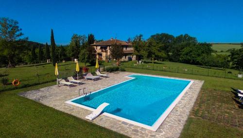 una piscina en un patio con sillas y una casa en La Casa Del Fattore, en Monteriggioni