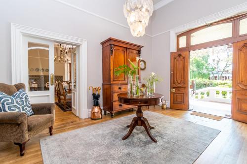 a living room with a table and a chair at Bonne Esperance Boutique Guest House in Stellenbosch