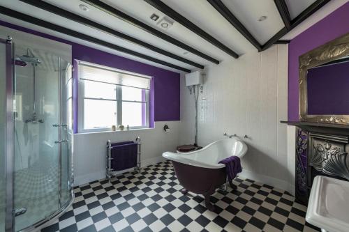 a bathroom with a tub and a glass shower at Evelix, The Old School House in Muir of Ord