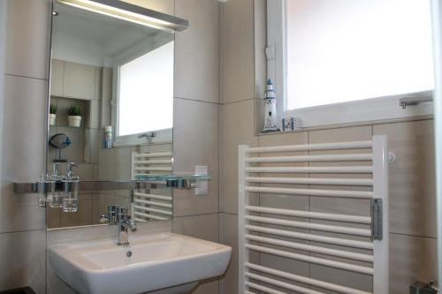 ein Bad mit einem Waschbecken und einem Spiegel in der Unterkunft Ferienwohnung Urlaubsflair Scharbeutz in Scharbeutz