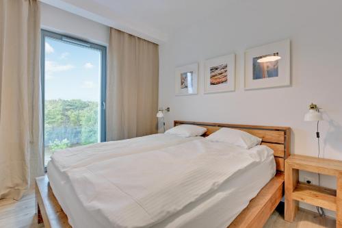 Un pat sau paturi într-o cameră la The Darling Nadmorze by Baltica Apartments