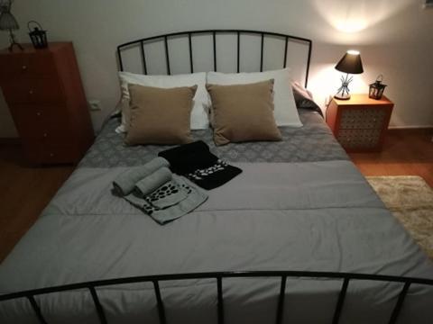 ein großes Bett mit weißen Laken und Kissen in der Unterkunft Évora Romana Alojamentos T1 Templo Diana in Évora