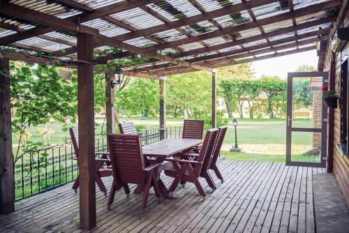 a wooden table and chairs on a wooden deck at Pamario Krašto Sodyba in Grumbliai
