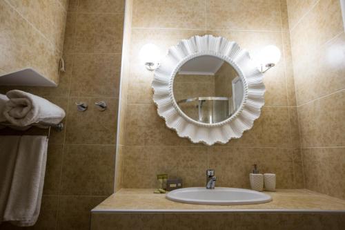 bagno con lavandino e specchio di Moriel Seaside Homes Suites a Elia